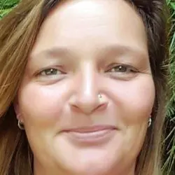 Headshot of Psychic Jody smiling with green plant background.