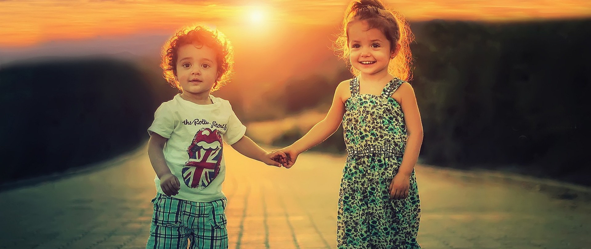 little boy and girl walking on road, holding hands