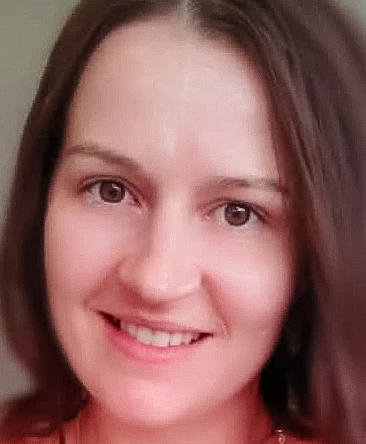 Psychic Jess smiling in a natural light headshot, brown hair, warm and approachable energy, professional psychic reader profile photo.