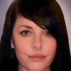 Psychic Reader Lucilla with long dark hair against a soft mystical background in deep plum and midnight blue tones, offering heartfelt psychic medium readings and intuitive spiritual guidance.